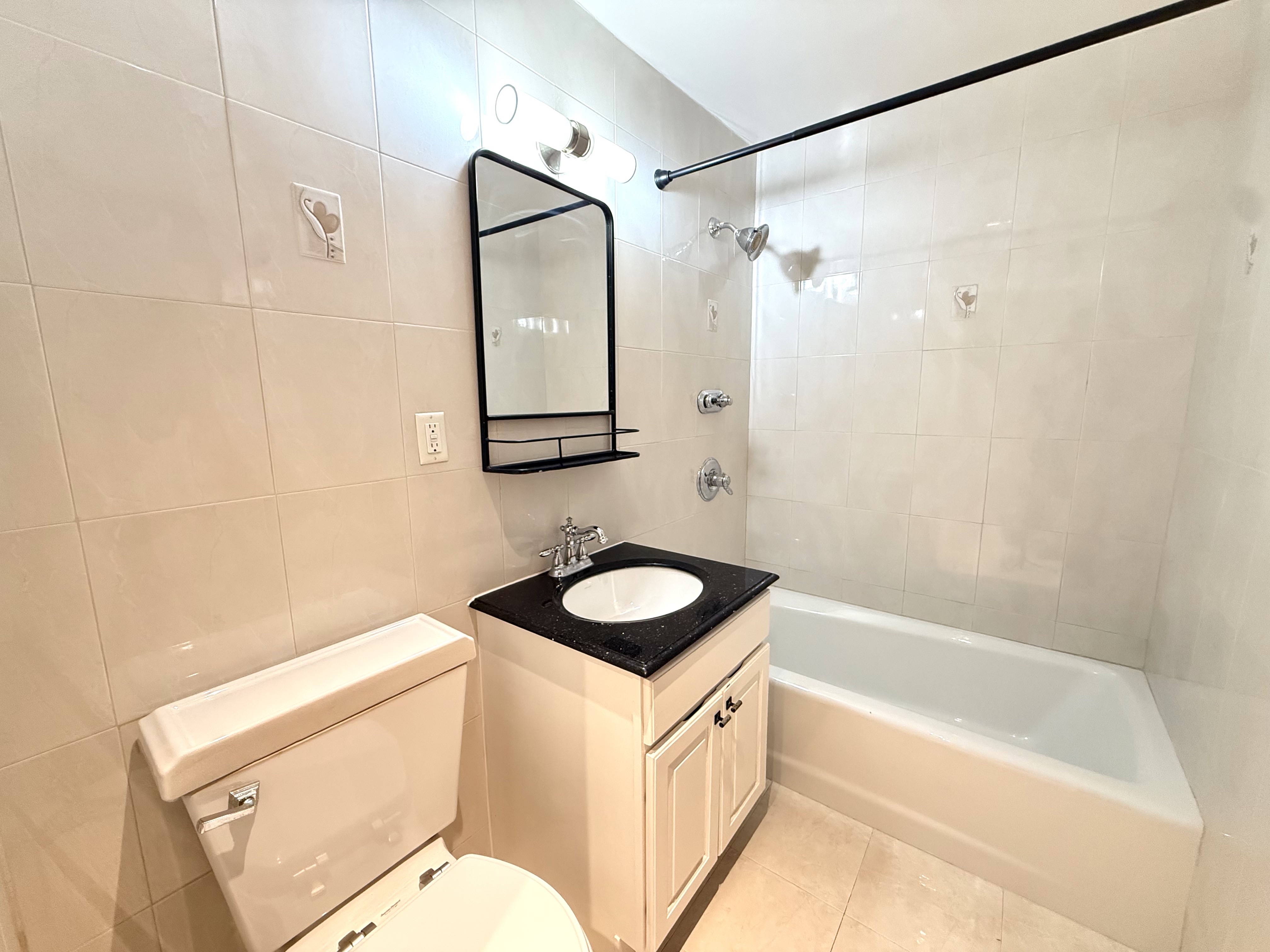433 West 162nd Street, Unit 1 Manhattan, NY 10032 - Photo 6 of 13 a bathroom with a sink a toilet a mirror and a bathtub