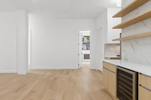 a view of a kitchen with wooden floor and a sink