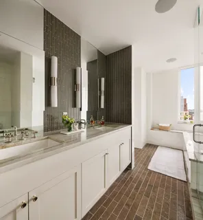 a spacious bathroom with a double vanity sink and mirror