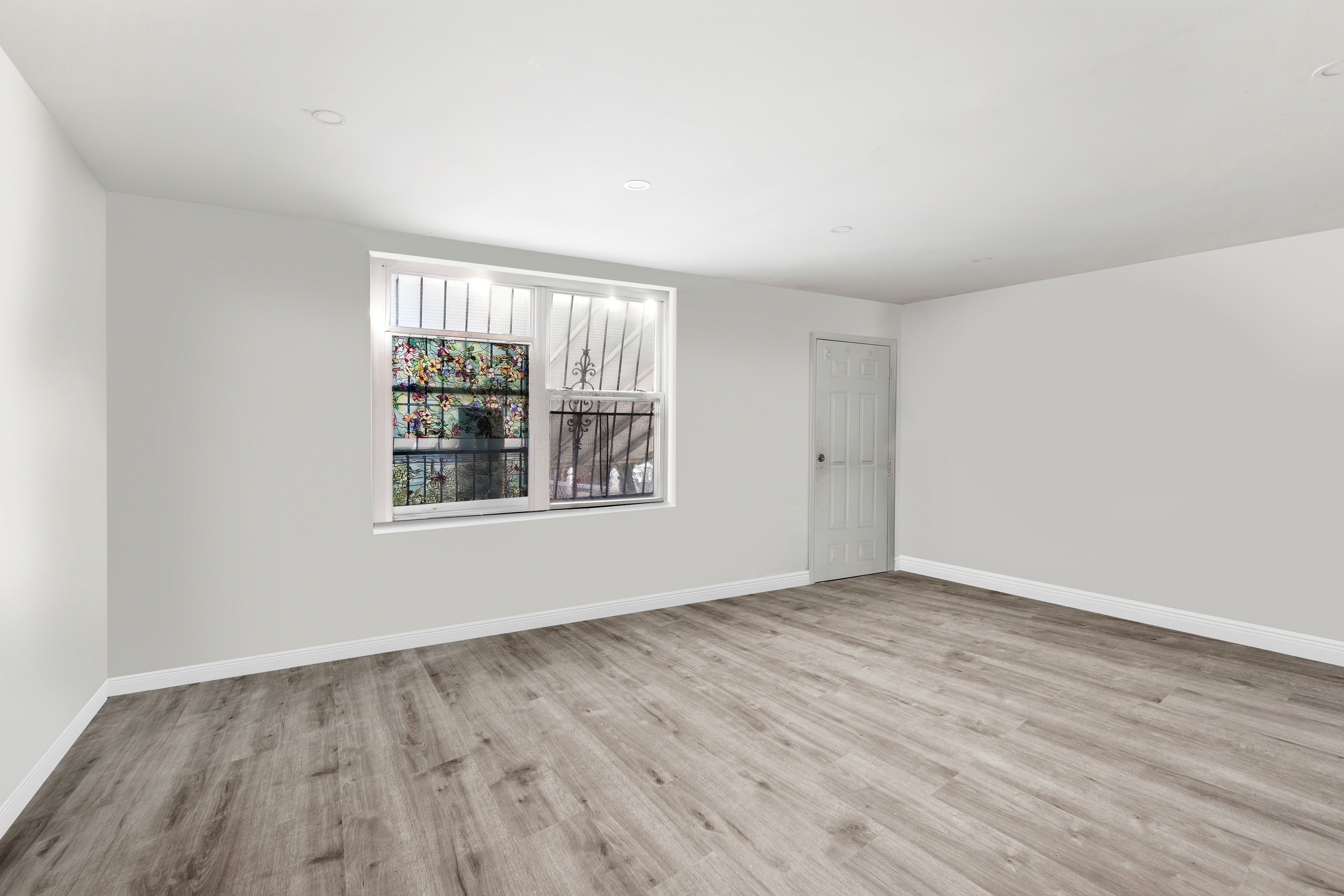 364 Chauncey Street Brooklyn, NY 11233 - Photo 12 of 17 a view of an empty room with wooden floor and a window