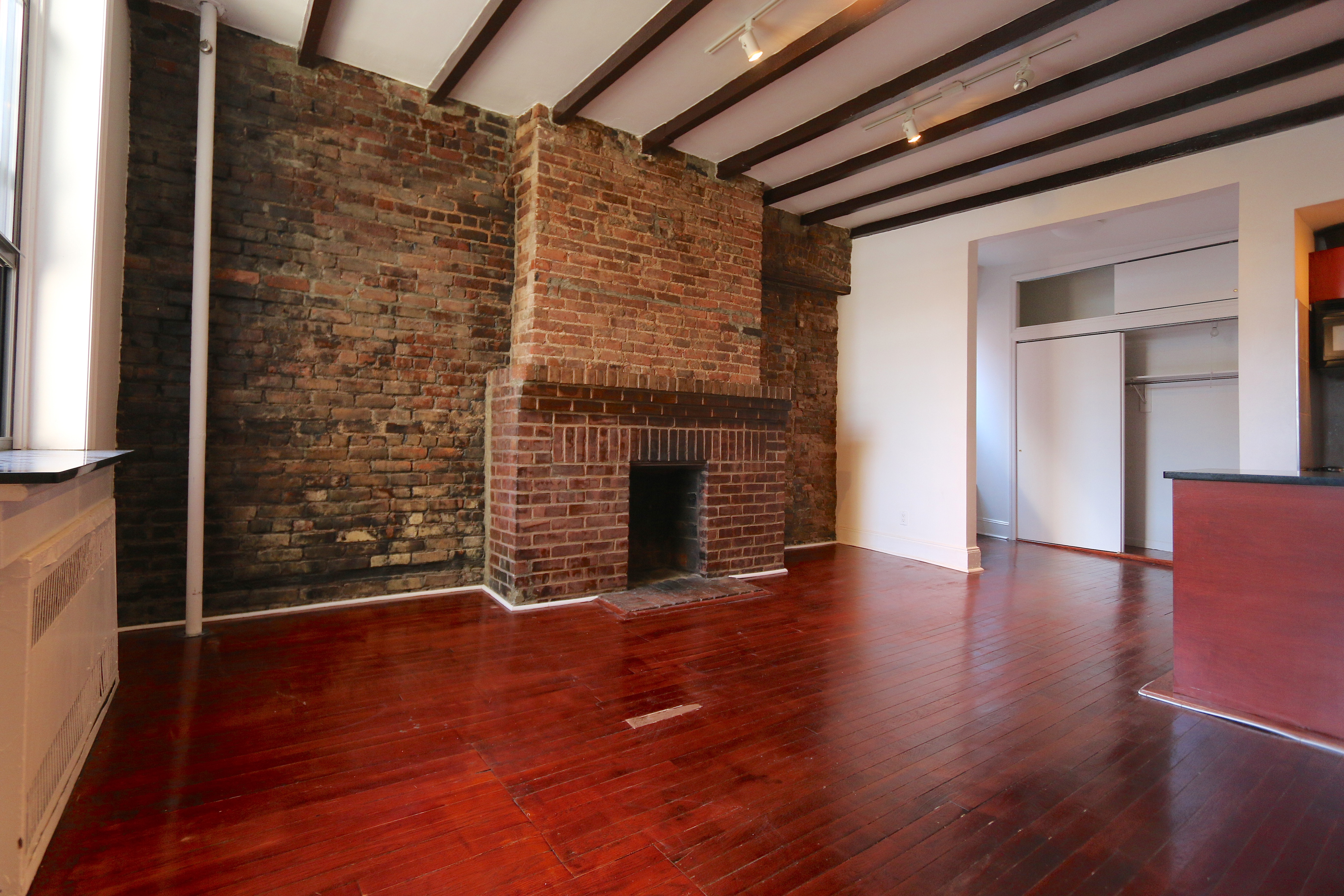 47 Jane Street Manhattan, NY 10014 - Photo 9 of 9 a view of an empty room with wooden floor and a window
