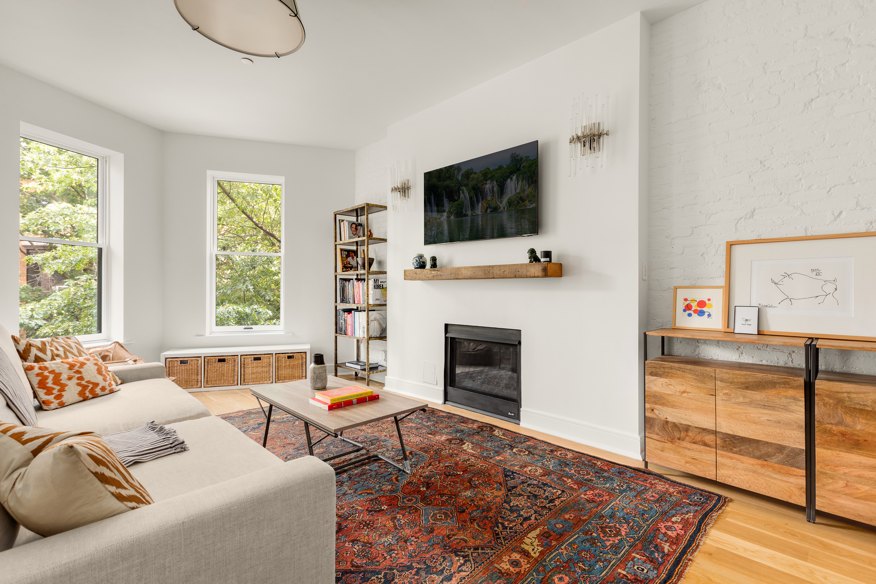 352 6th Avenue, Unit 3 Brooklyn, NY 11215 - Photo 4 of 14 a living room with furniture a flat screen tv and a fireplace