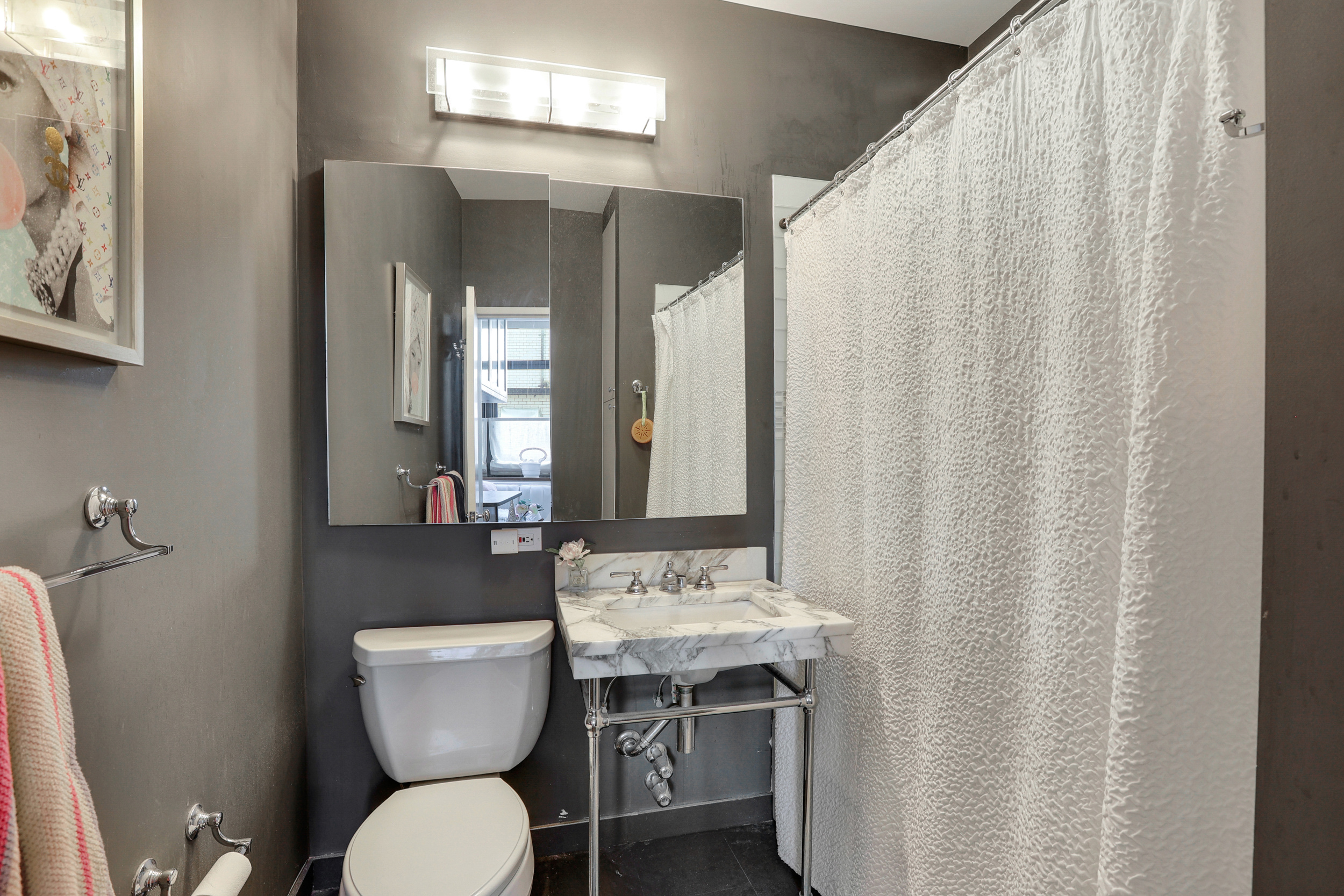 310 East 46th Street, Unit 16B Manhattan, NY 10017 - Photo 7 of 7 a bathroom with a toilet a sink and a mirror