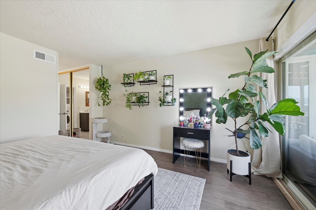 6373 Rancho Mission Road, Unit 5 San Diego, CA 92108 - Photo 15 of 30 a bedroom with a bed potted plant and a window
