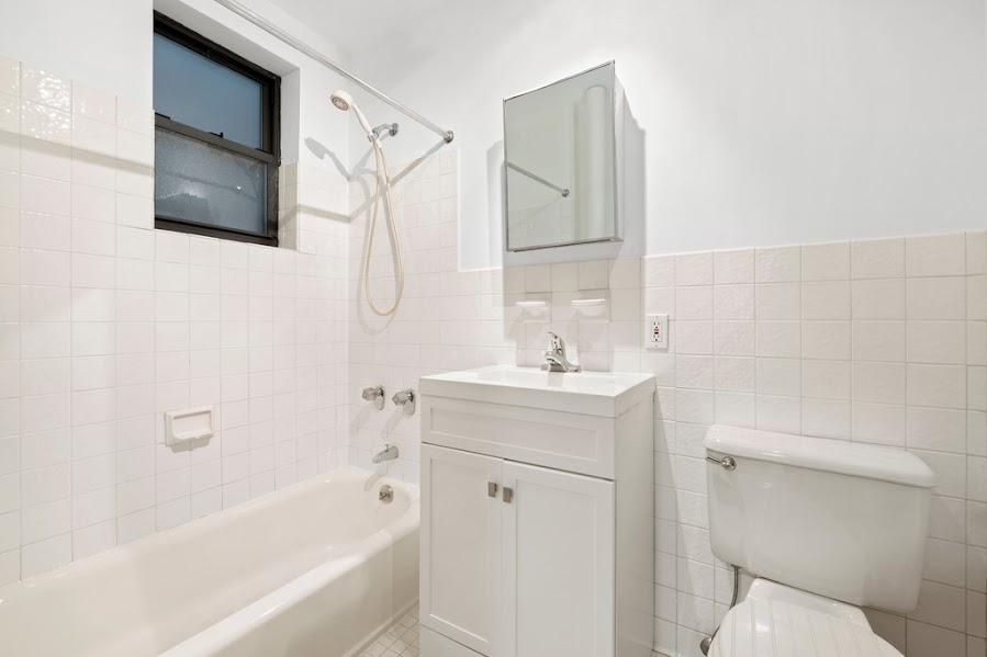 312 West 49th Street, Unit 1RW Manhattan, NY 10019 - Photo 11 of 12 a bathroom with a sink a toilet and shower