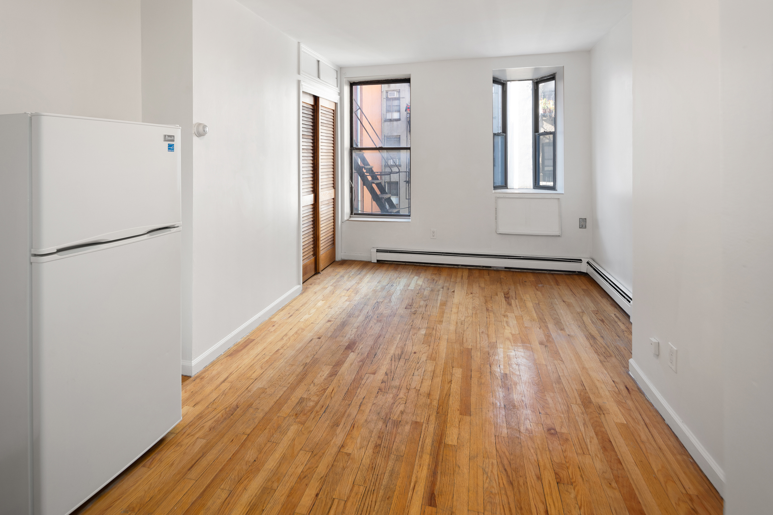 101 Allen Street, Unit 2D Manhattan, NY 10002 - Photo 1 of 4 a view of a room with wooden floor and refrigerator