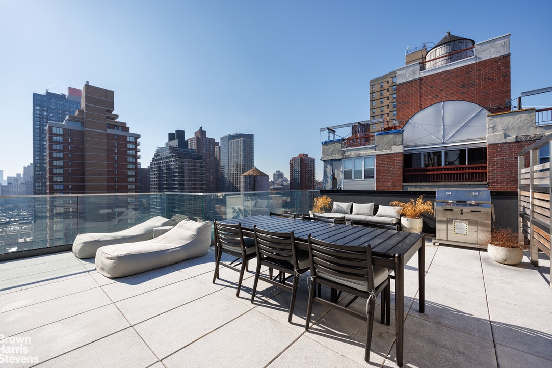 302 East 96th Street, Unit 1103 Manhattan, NY 10128 - Photo 19 of 22 a view of a patio with couches and a potted plant on a table