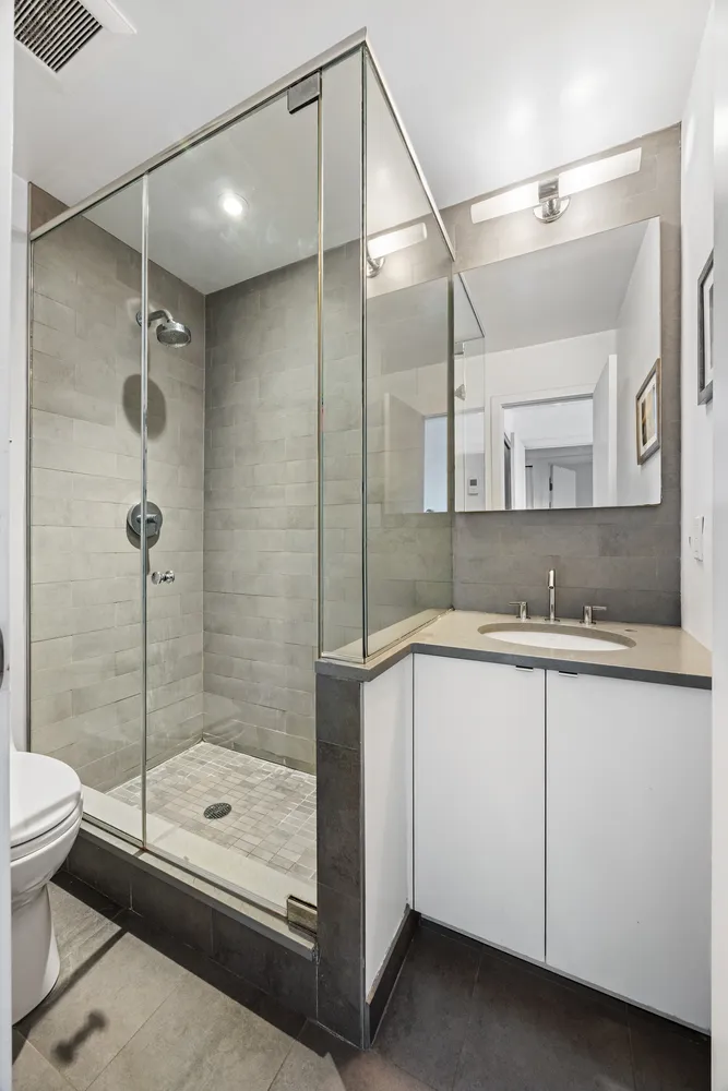 a bathroom with a shower sink and mirror