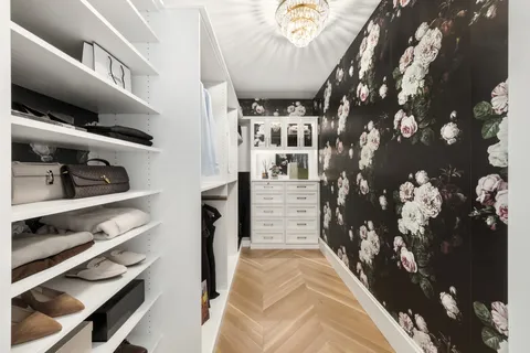 a view of walk in closet with clothes and shoes