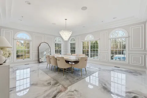 a view of a dining room with furniture a chandelier and wooden floor