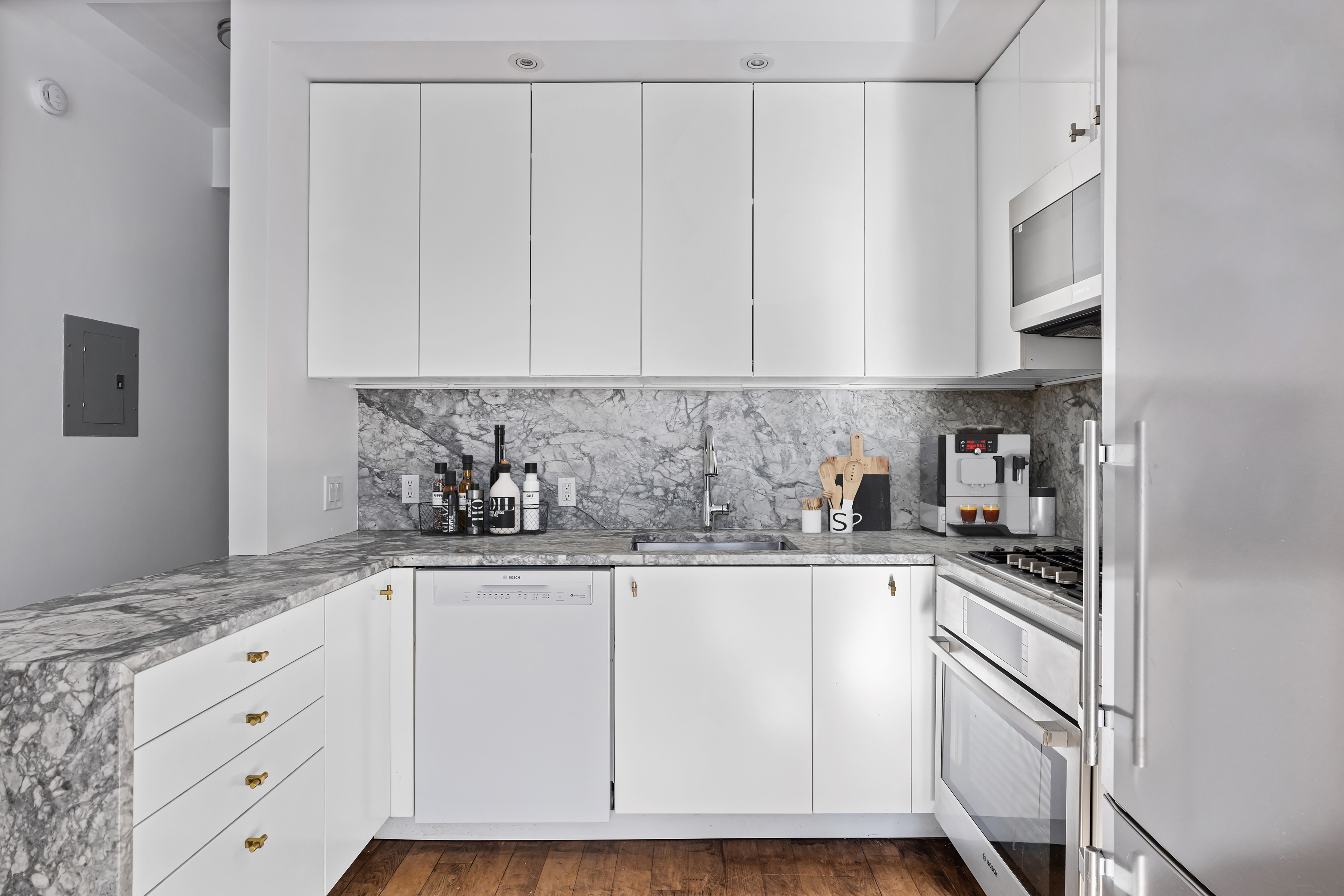 242 South 1st Street, Unit 4E Brooklyn, NY 11211 - Photo 5 of 15 a kitchen with granite countertop white cabinets and white appliances