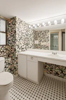 a hallway with cabinets a sink and a large window