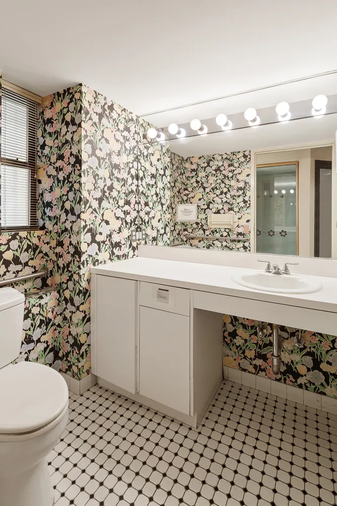 a hallway with cabinets a sink and a large window