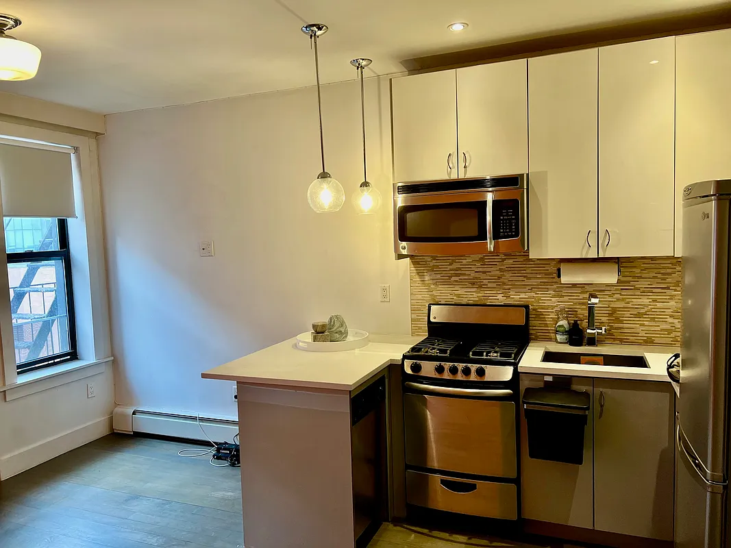 a kitchen with stainless steel appliances a stove a sink and a microwave