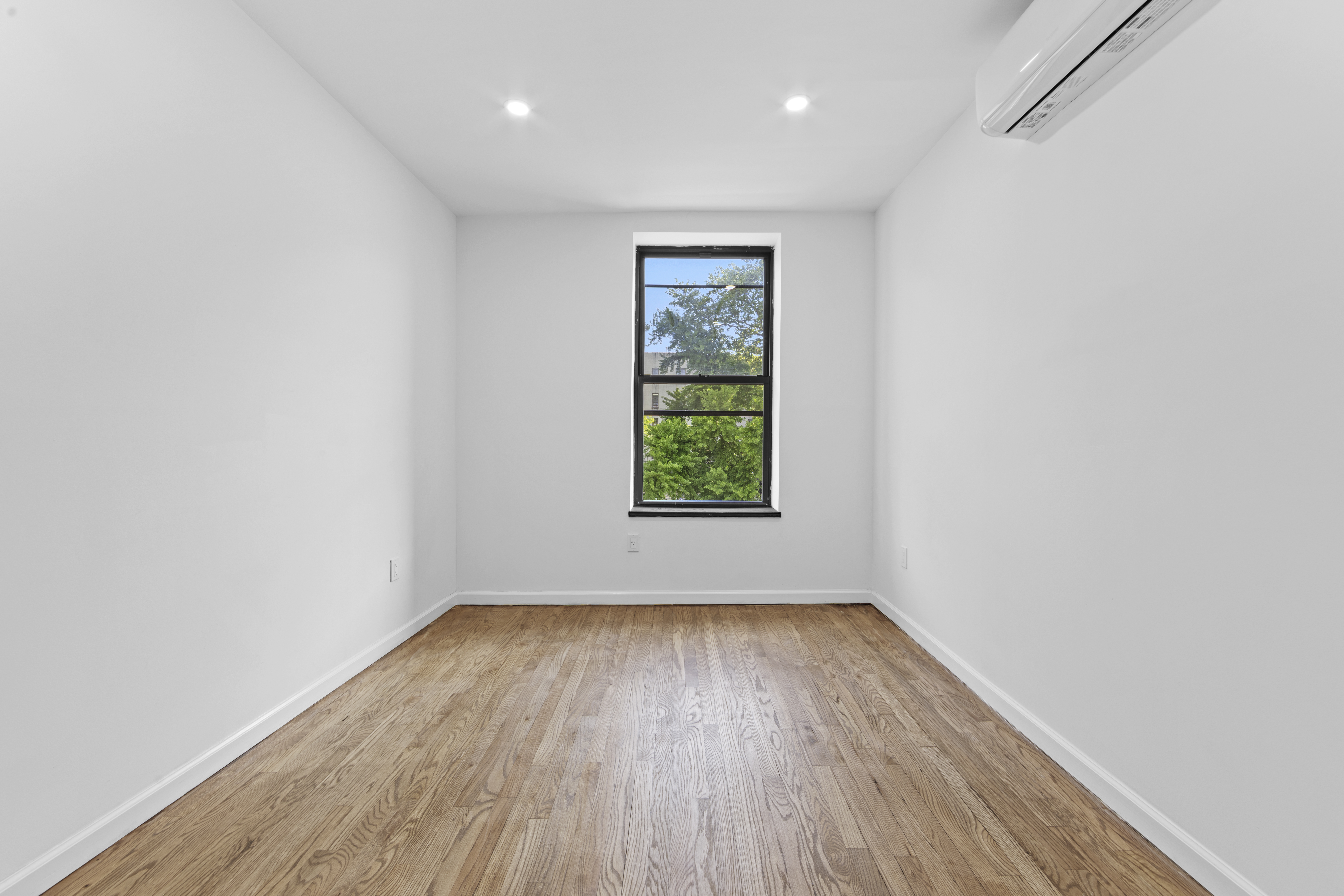 1061 Fulton Street, Unit 3 Brooklyn, NY 11238 - Photo 9 of 14 a view of an empty room with wooden floor and a window