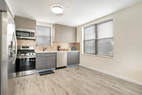 a kitchen with stainless steel appliances kitchen island granite countertop a stove a sink and a refrigerator