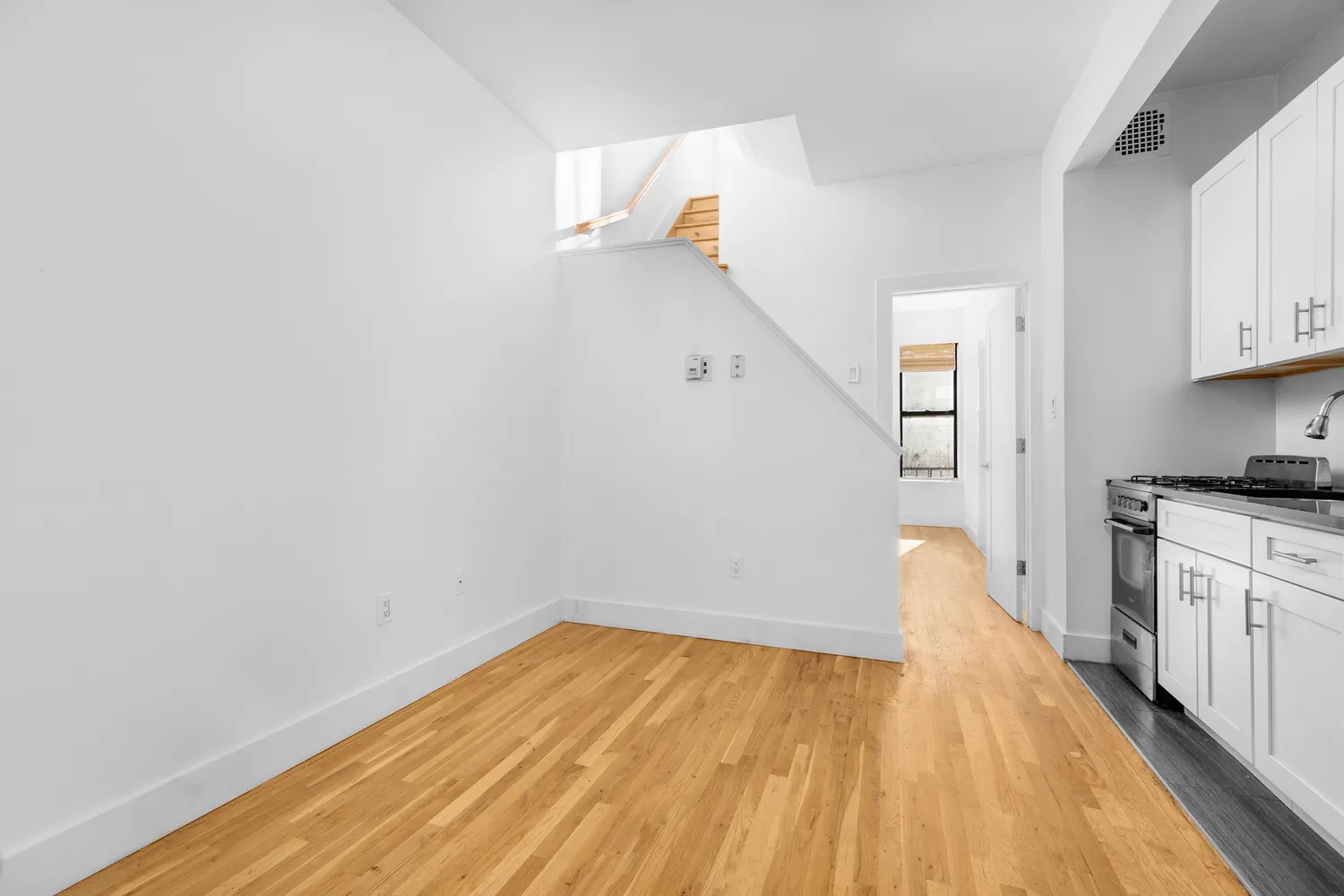 a view of a kitchen with wooden floor and a sink