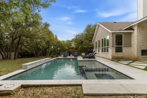 a view of a white house with swimming pool and a yard