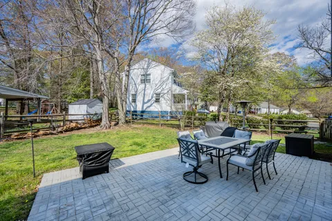 a view of a house with backyard sitting area and garden