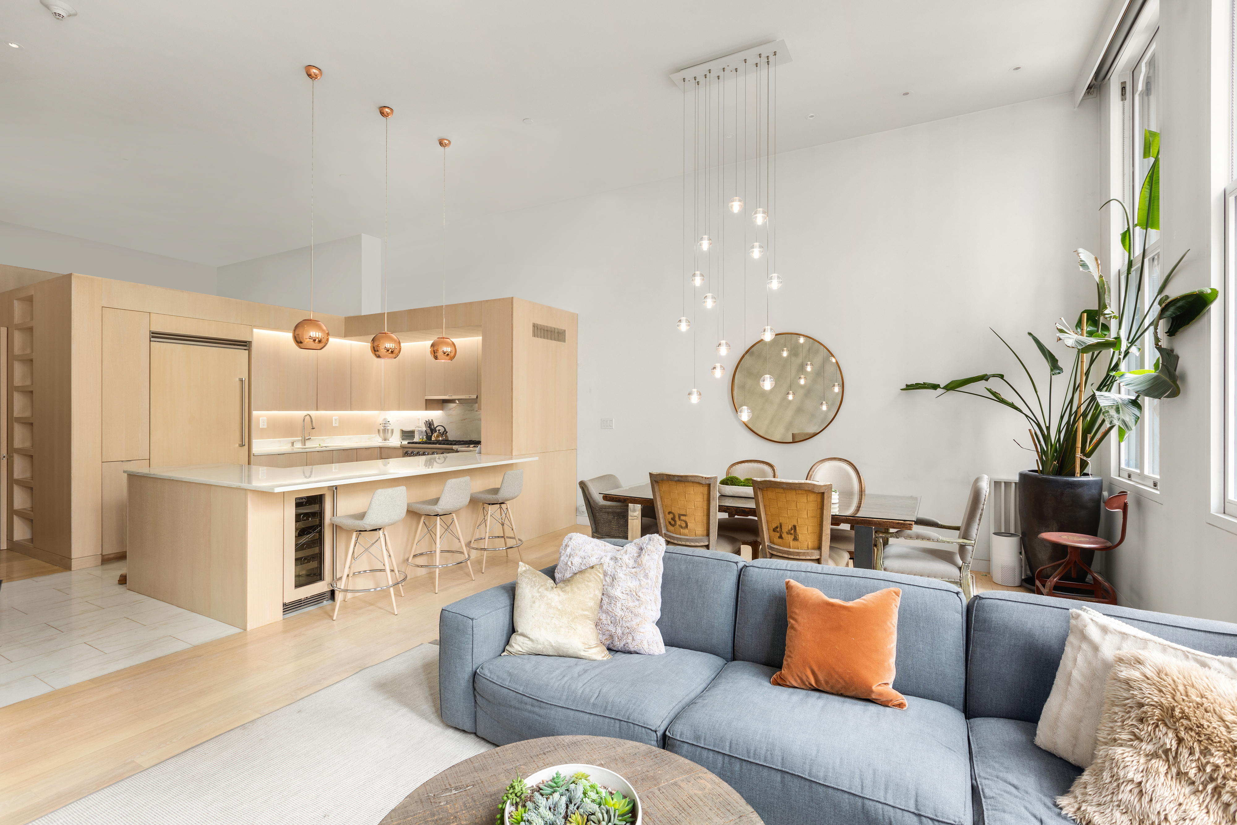 93 Reade Street, Unit 2 Manhattan, NY 10013 - Photo 2 of 9 a living room with furniture a chandelier and kitchen view