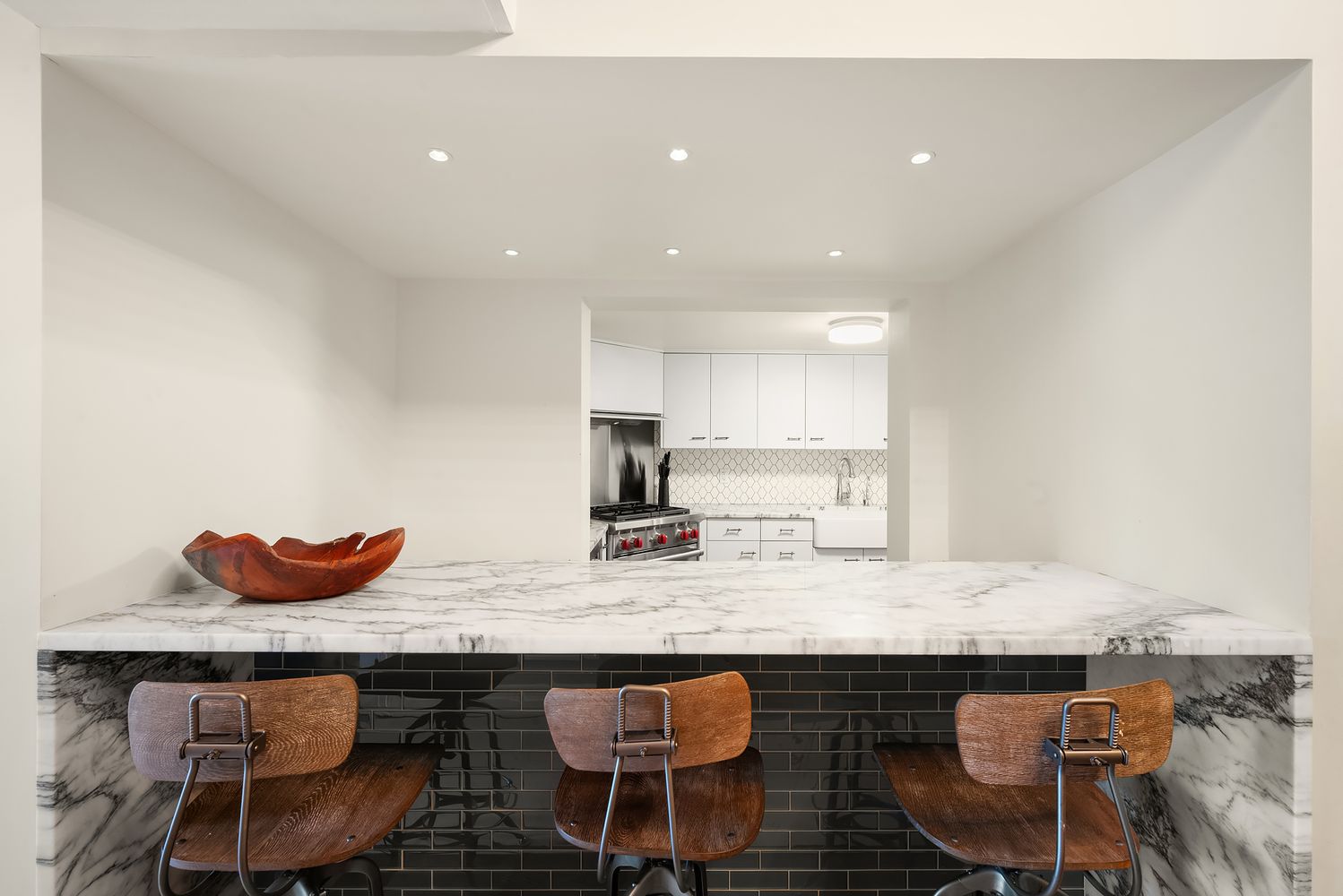 421 Hudson Street, Unit 306 Manhattan, NY 10014 - Photo 4 of 12 a kitchen with granite countertop a table chairs stove and granite counter top