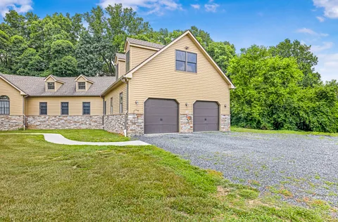 a view of a white house with a swimming pool and a yard
