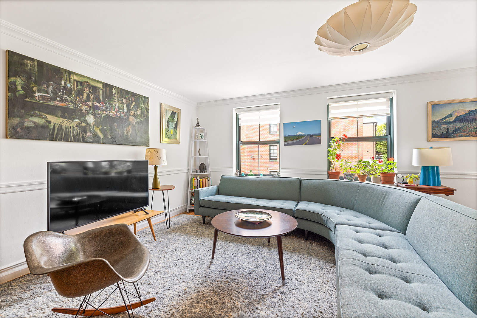 a living room with furniture a flat screen tv and a window