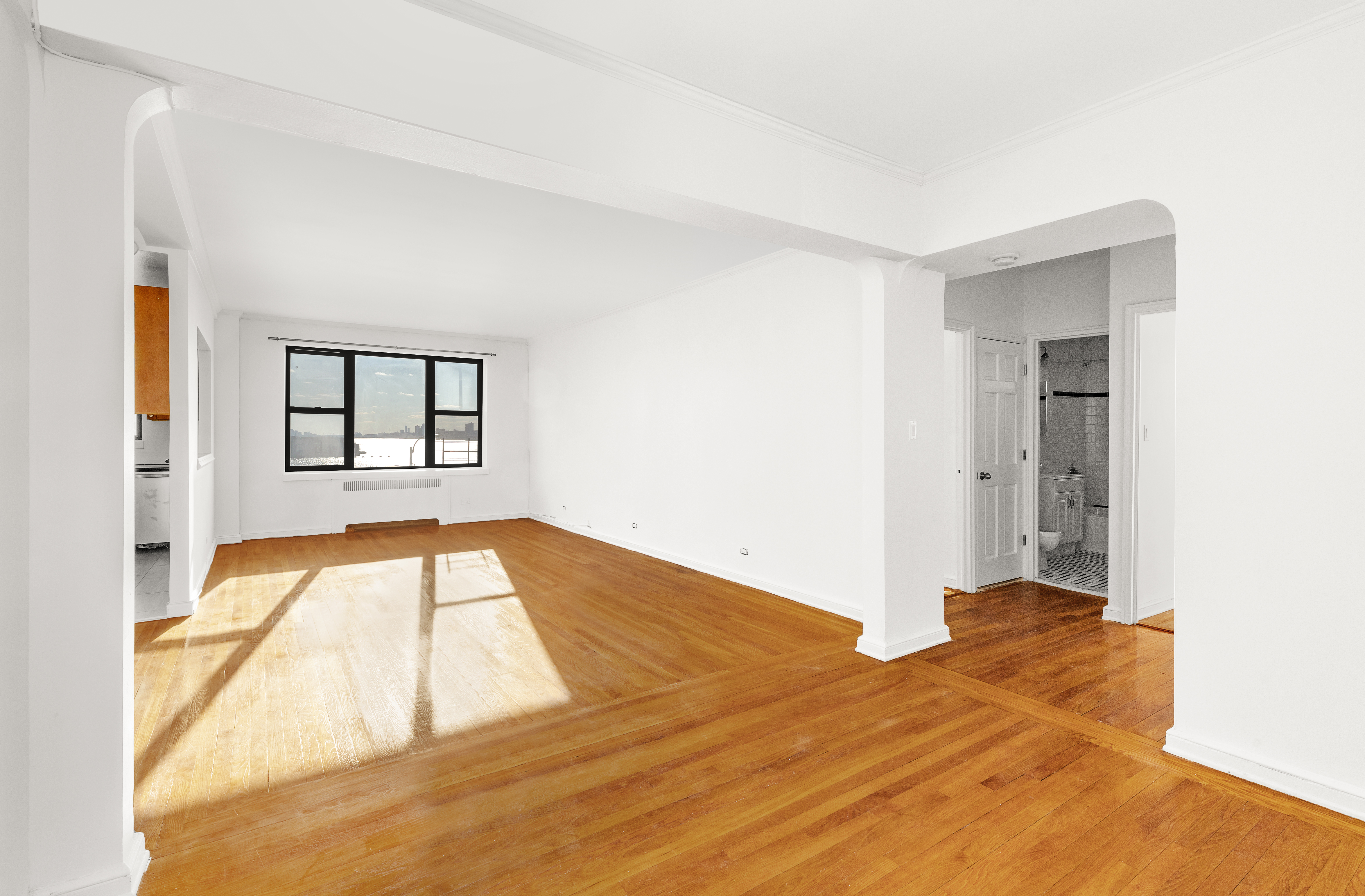 158-18 Riverside Drive West, Unit 4E50 Manhattan, NY 10032 - Photo 2 of 17 a view of an empty room with wooden floor and a window