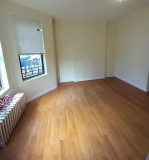 an empty room with wooden floor and chandelier