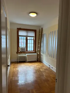 a view of an empty room with a fireplace and a window