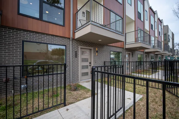 a view of a brick building and iron fence