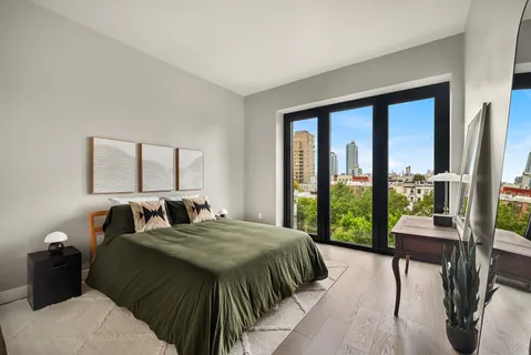 a bedroom with a bed and a large window