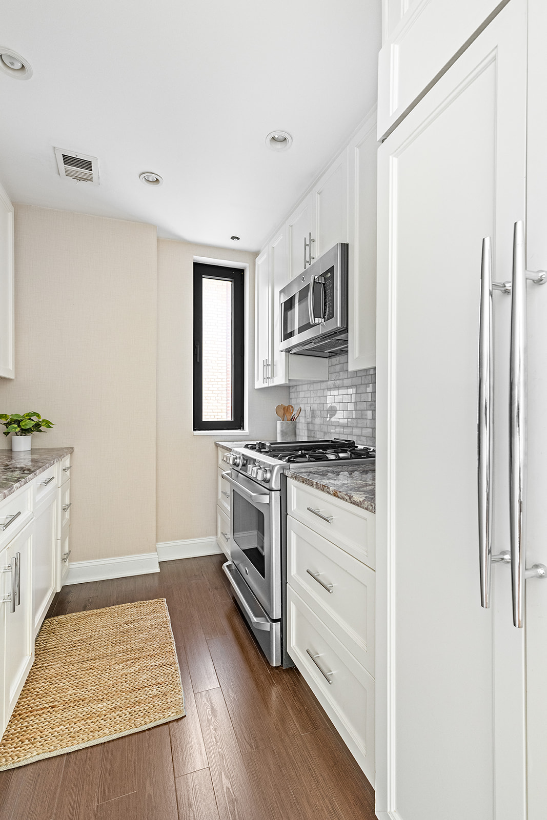350 East 72nd Street, Unit 12A Manhattan, NY 10021 - Photo 3 of 9 a kitchen with stainless steel appliances granite countertop a stove a sink and a refrigerator