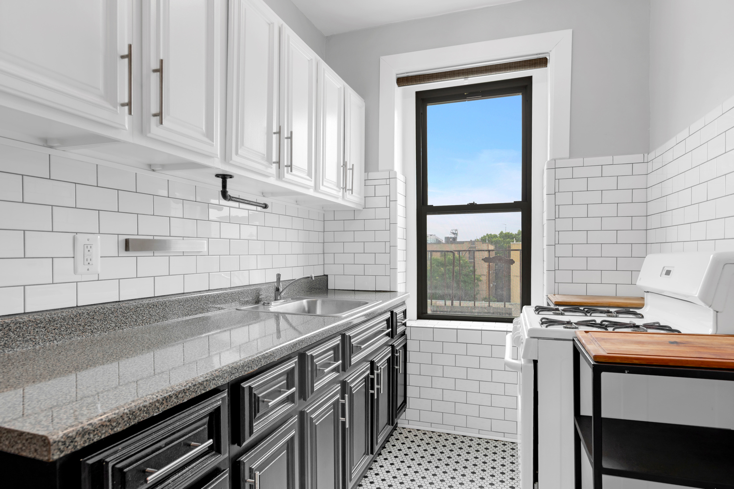 37-20 83rd Street, Unit 6J Queens, NY 11372 - Photo 7 of 14 a kitchen with granite countertop a sink a stove and wooden cabinets
