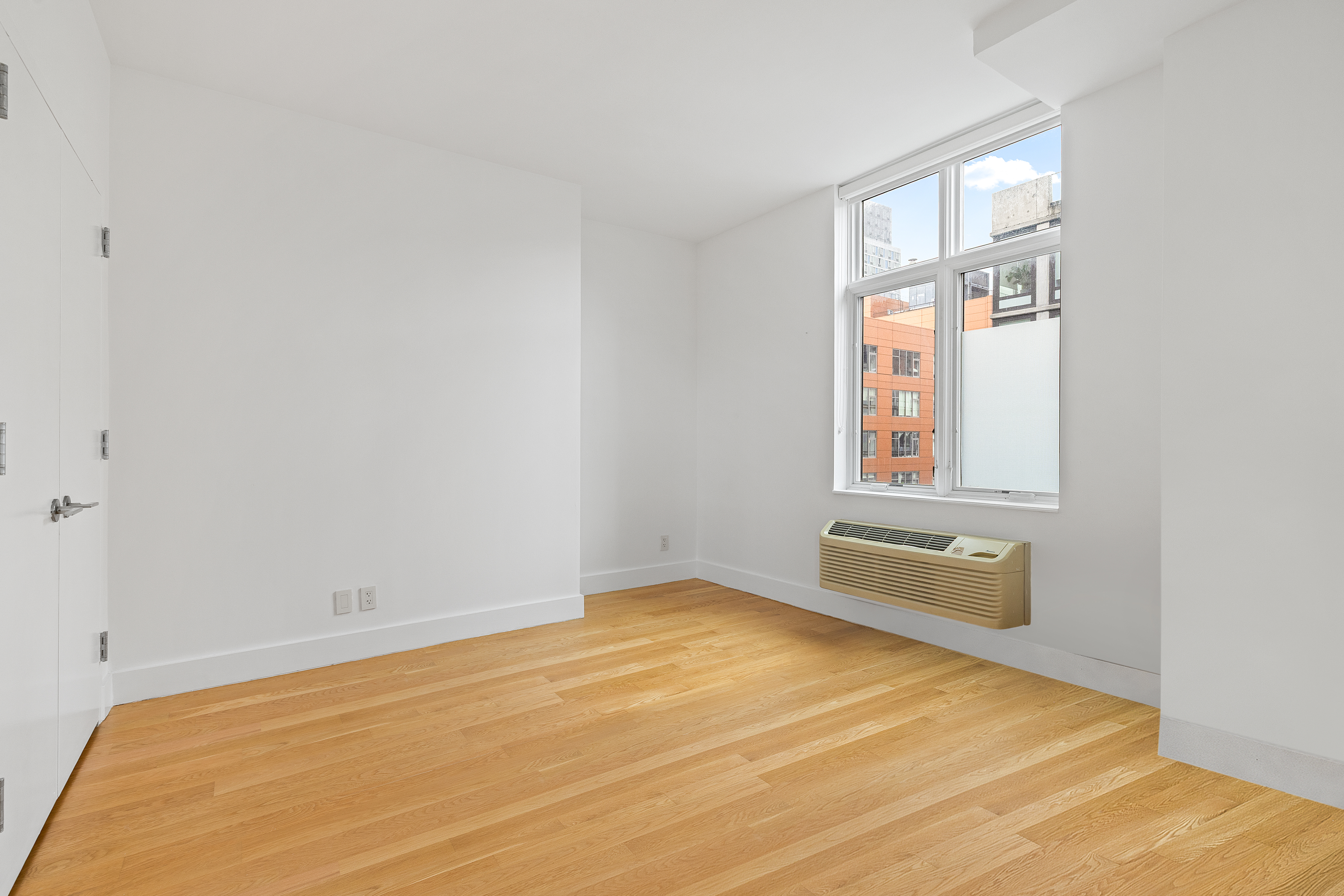 2-26 50th Avenue, Unit 10F Queens, NY 11101 - Photo 5 of 11 an empty room with windows