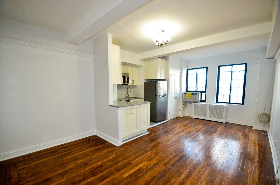a view of kitchen with wooden floor and electronic appliances