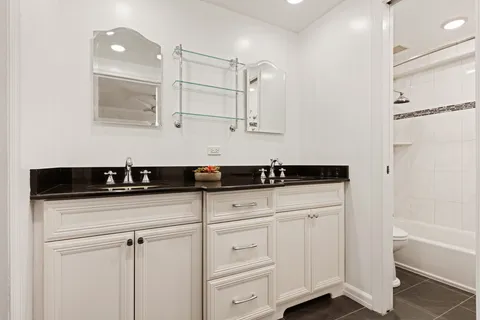 a kitchen with white cabinets and sink