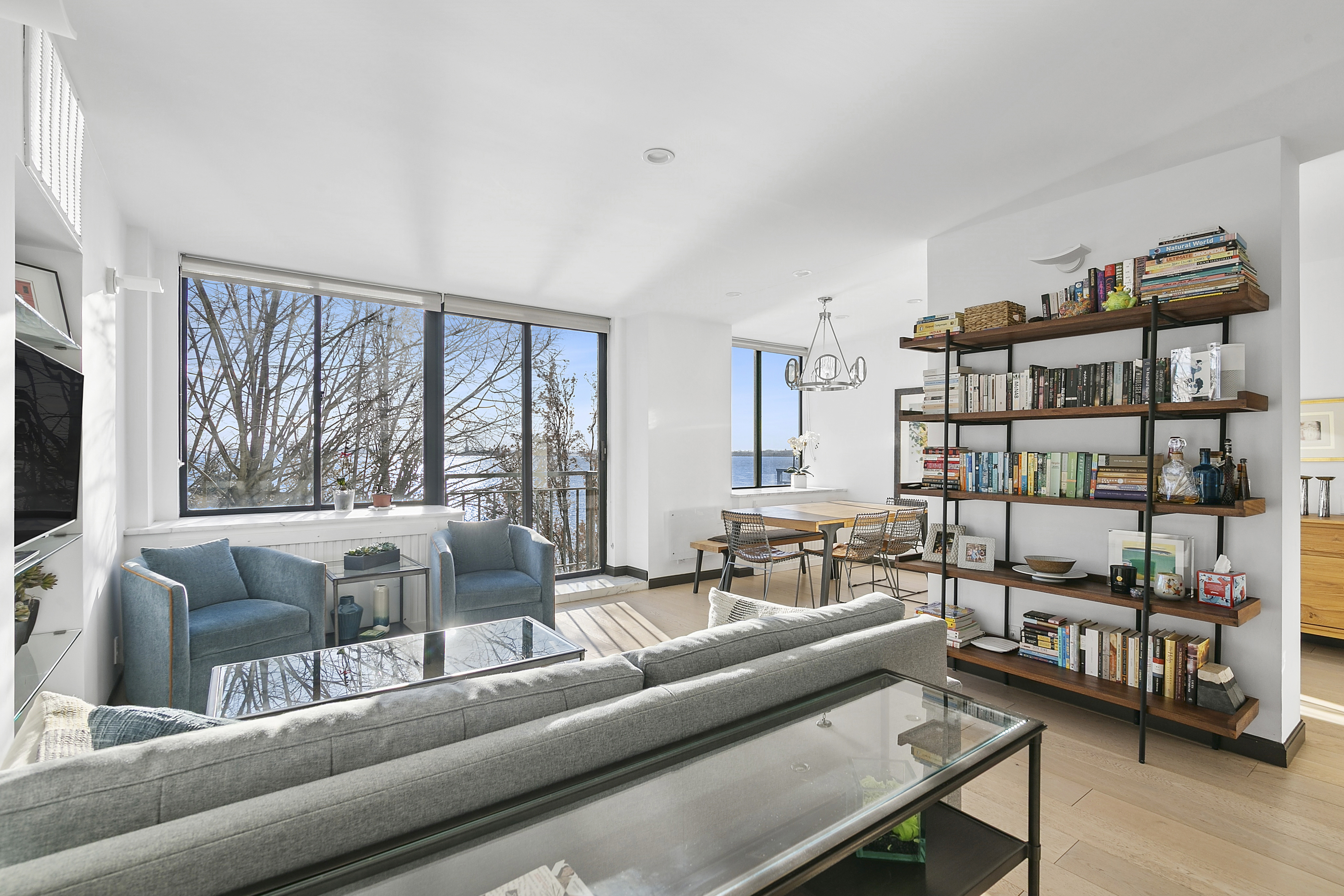 21 South End Avenue, Unit 402 Manhattan, NY 10280 - Photo 1 of 13 a living room with furniture and a book shelf