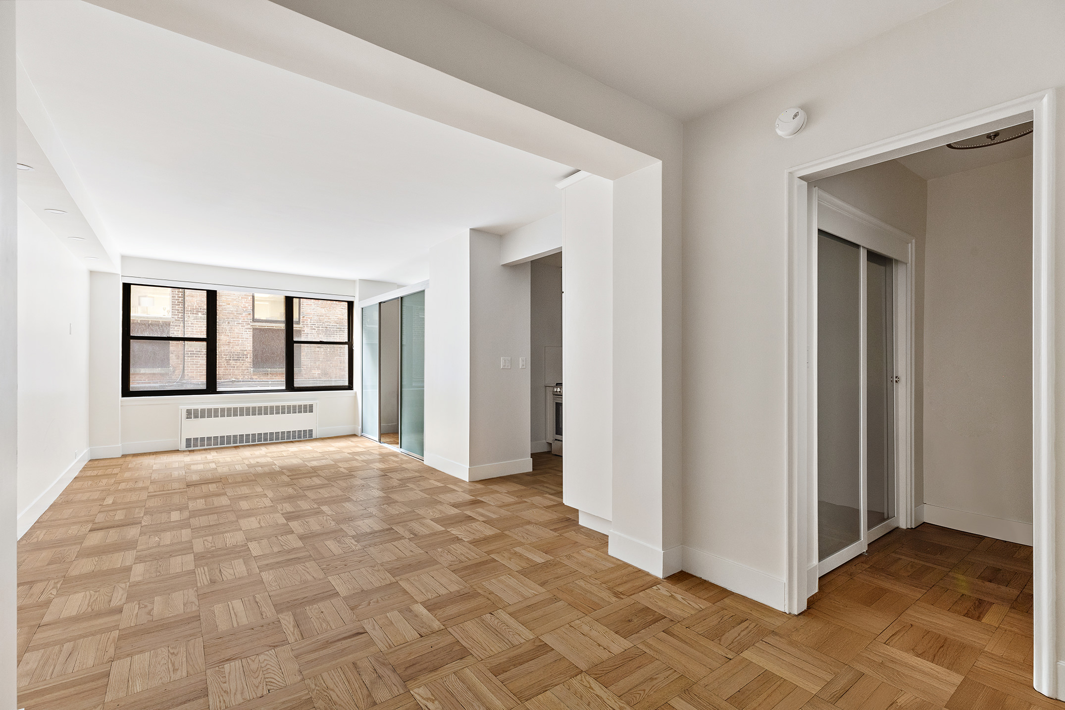49 West 12th Street, Unit 1A Manhattan, NY 10011 - Photo 2 of 8 a view of an empty room with window and cabinet