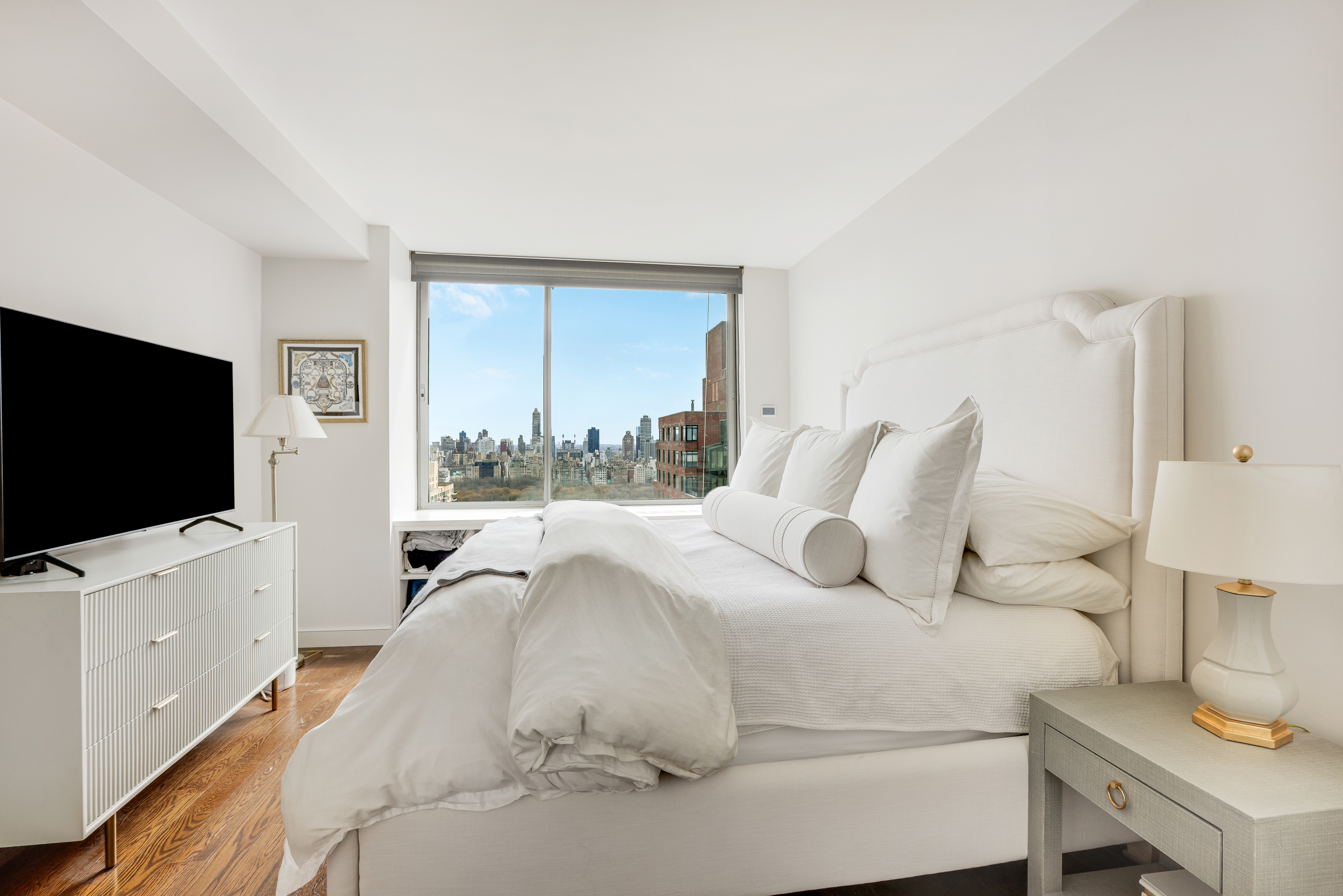 111 West 67th Street, Unit 34F Manhattan, NY 10023 - Photo 6 of 11 a bedroom with a bed and a flat screen tv