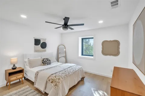 a bedroom with a bed and a painting on the wall