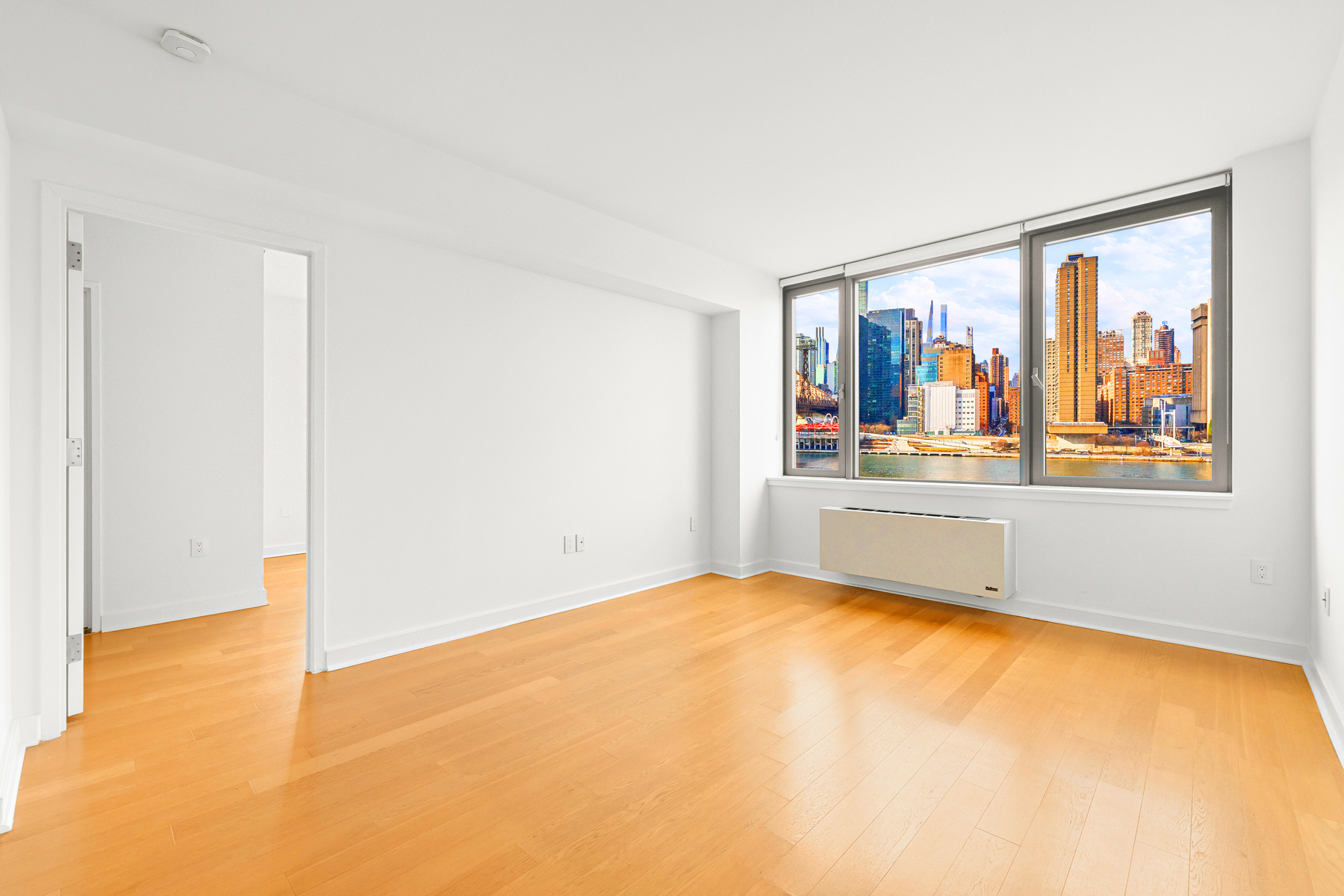 425 Main Street, Unit 9F Manhattan, NY 10044 - Photo 10 of 15 a view of a room with wooden floor and a window