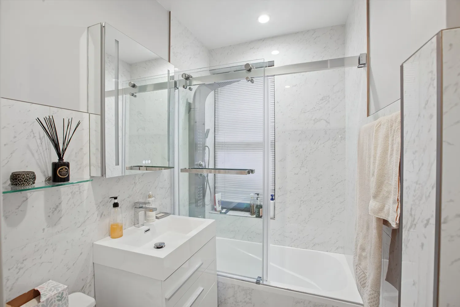 a bathroom with a tub sink vanity and mirror