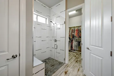 a bathroom with a granite countertop shower a sink and a mirror