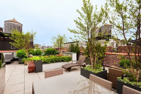 a view of a patio with couches table and chairs and potted plants