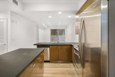 a kitchen with stainless steel appliances granite countertop a refrigerator and a sink