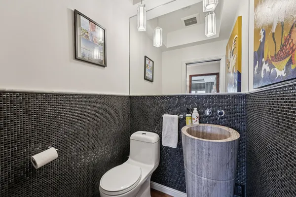 a bathroom with a toilet a sink and mirror