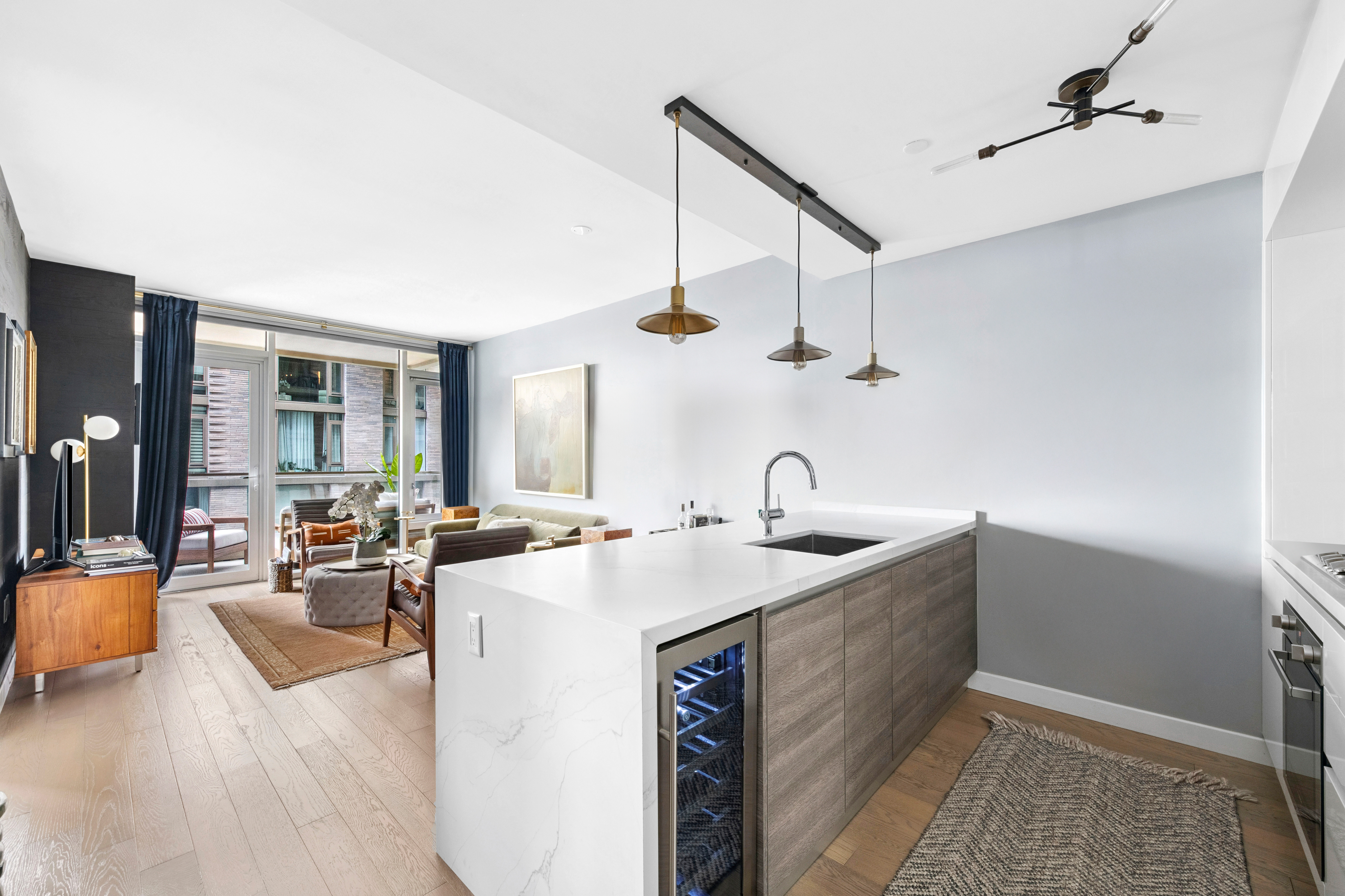 505-513 West 43rd Street, Unit 6K Manhattan, NY 10036 - Photo 2 of 16 a kitchen with sink stove and living room