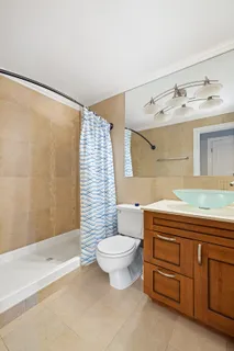 a bathroom with a granite countertop sink a toilet and bathtub
