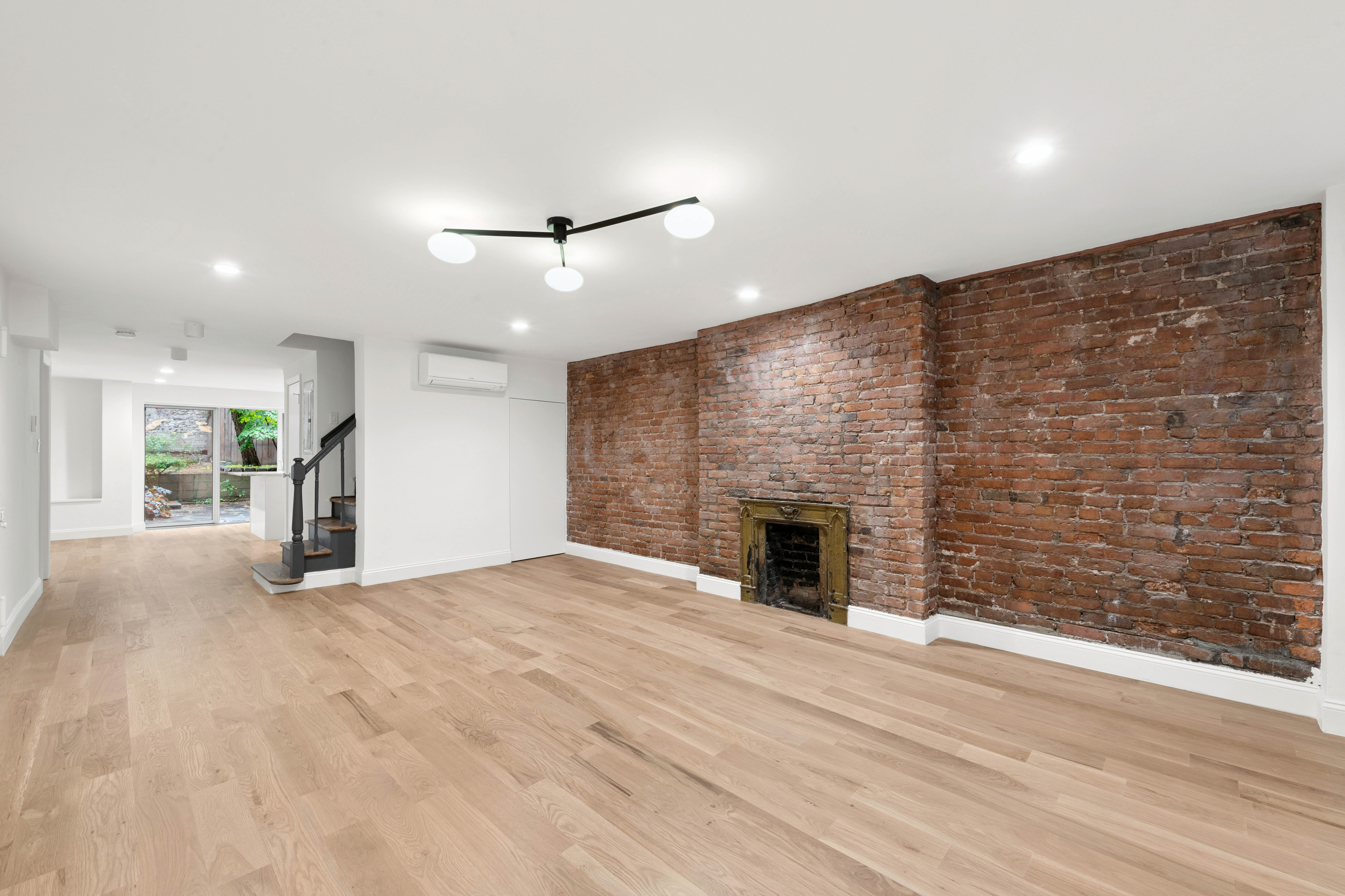 765 Greenwich Street, Unit 1 Manhattan, NY 10014 - Photo 7 of 14 a view of empty room with wooden floor and fireplace